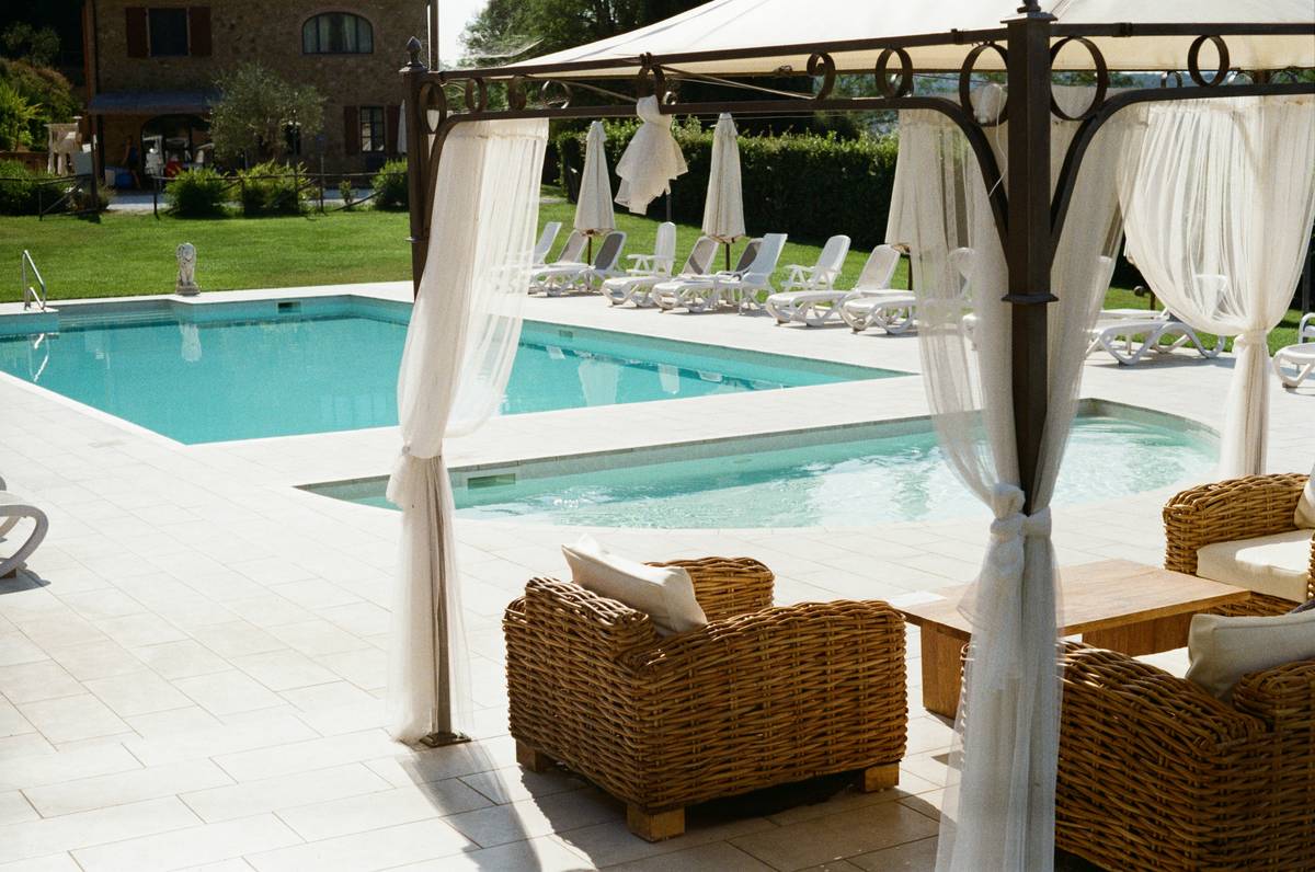 Versatile pool furniture design ideas showing modular seating arrangements with movable ottomans and compact side tables around a residential pool
